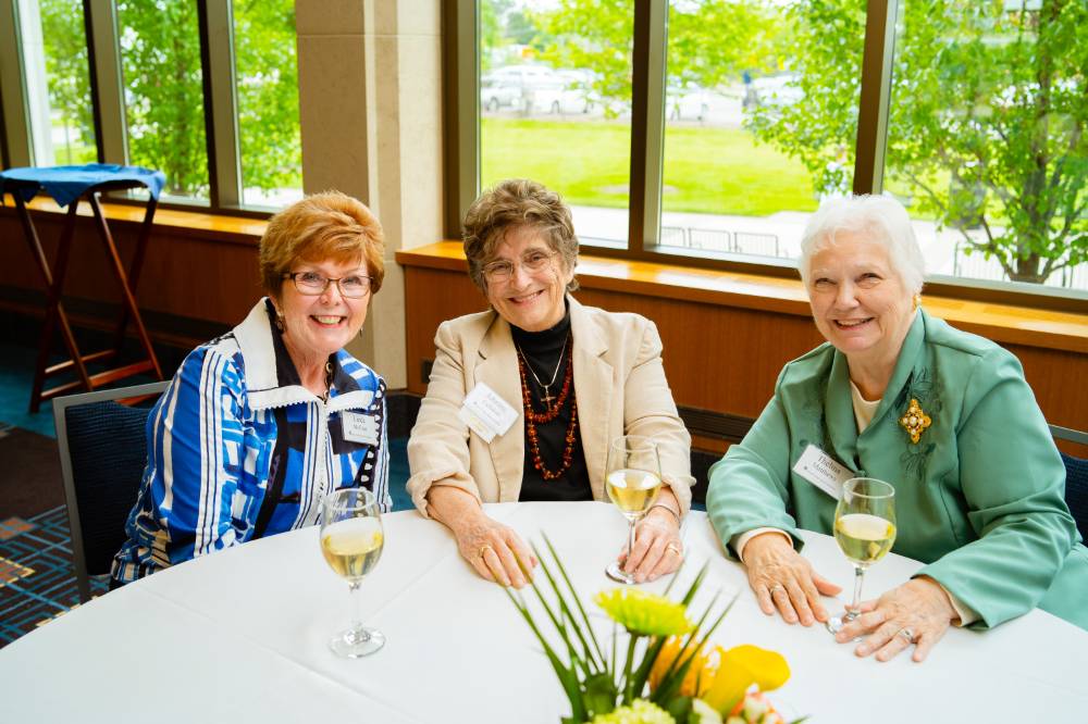 Three guests sitting at a table at the Retiree Reception.